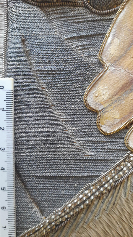 Dettaglio della mano di Menelik II e i vari intrecci delle vesti, con variazioni nell’orientamento, nella tonalità e nel rilievo dei fili metallici.