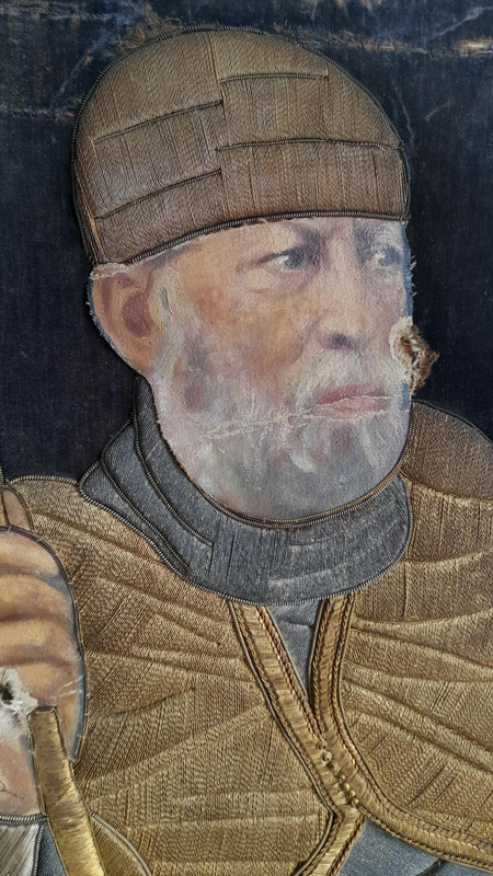 ettaglio del volto di Menelik II dipinto e della struttura tessile in rilievo. Sono visibili lacune dello strato pittorico e una lacuna perforante.